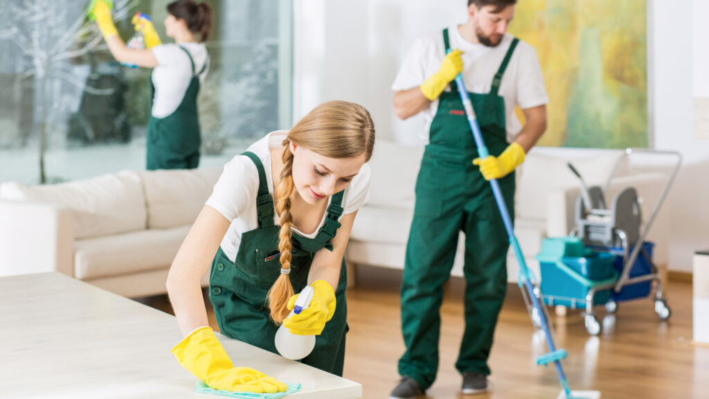 Two women and a male spring cleaning the inside of a house