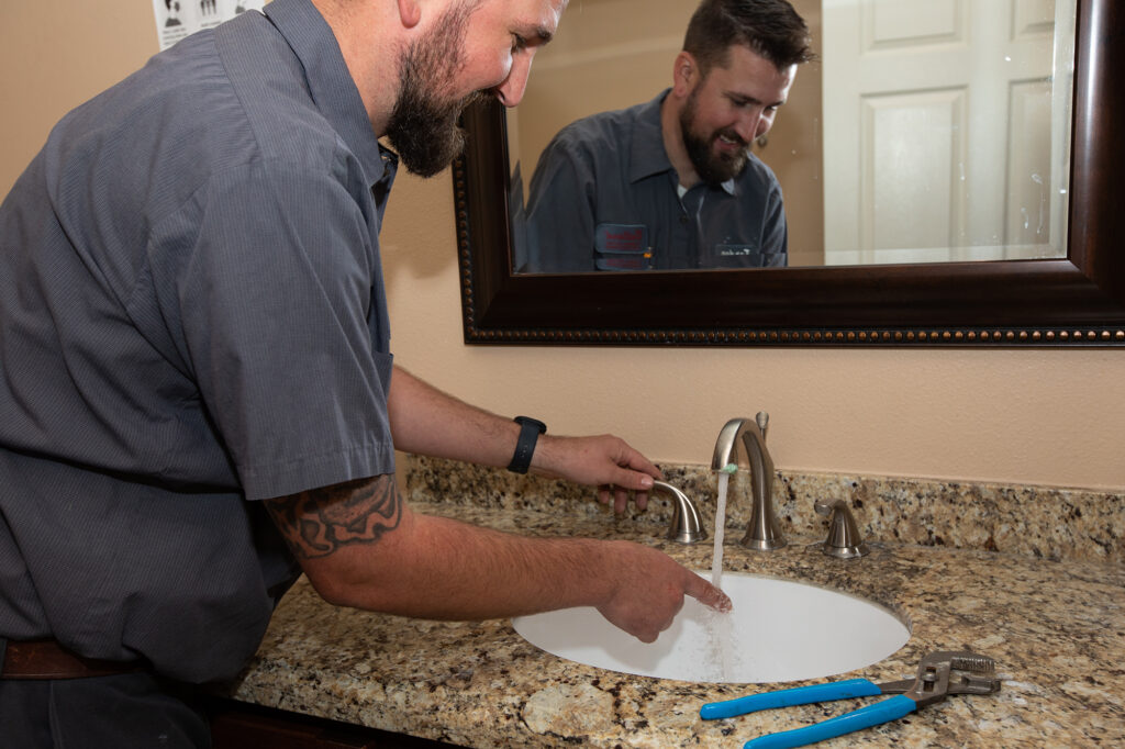 Plumber installing a bathroom sink at a San Bernardino area home